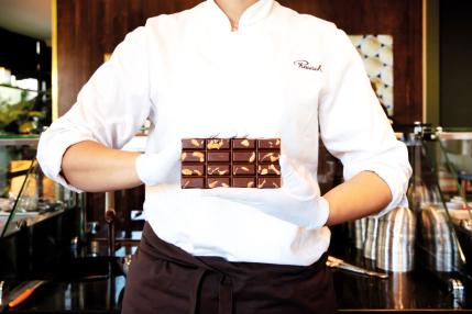Une vendeuse présente une tablette de chocolat Rausch