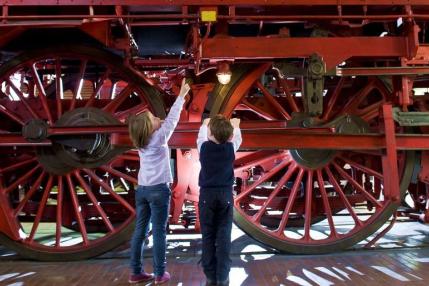 kids playing under an old train