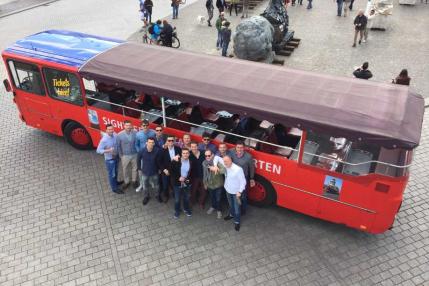 Berlin Erlebnisse, Gruppe vor rotem Sightseeing-Bus
