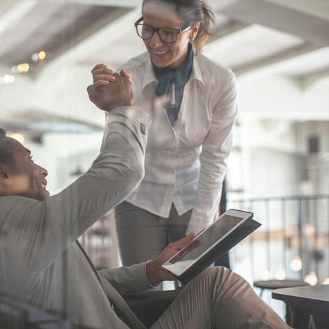 Mann und Frau in Business Kleidung geben sich die Hand